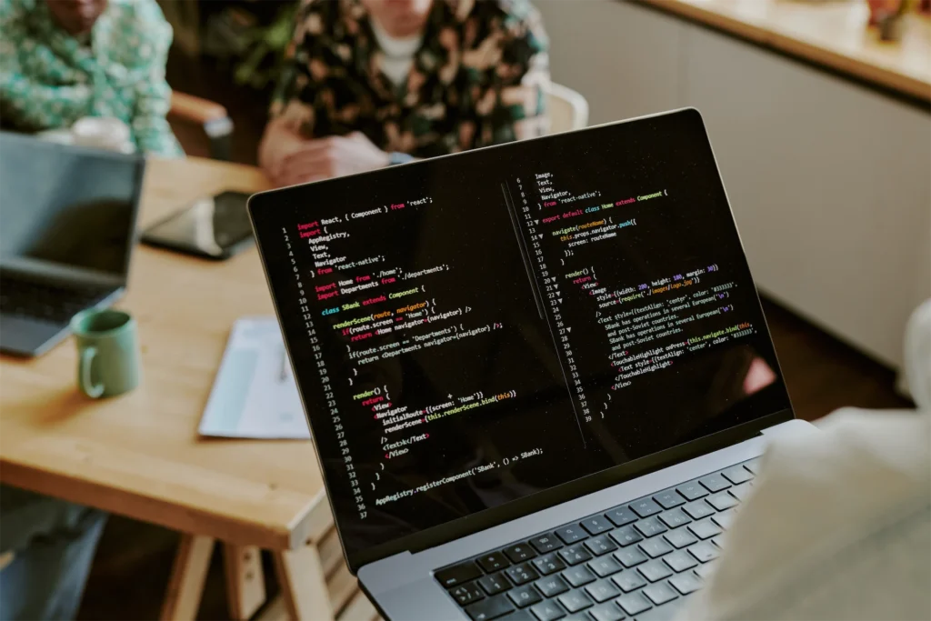 SEO specialist presenting schema markup code on laptop in team meeting