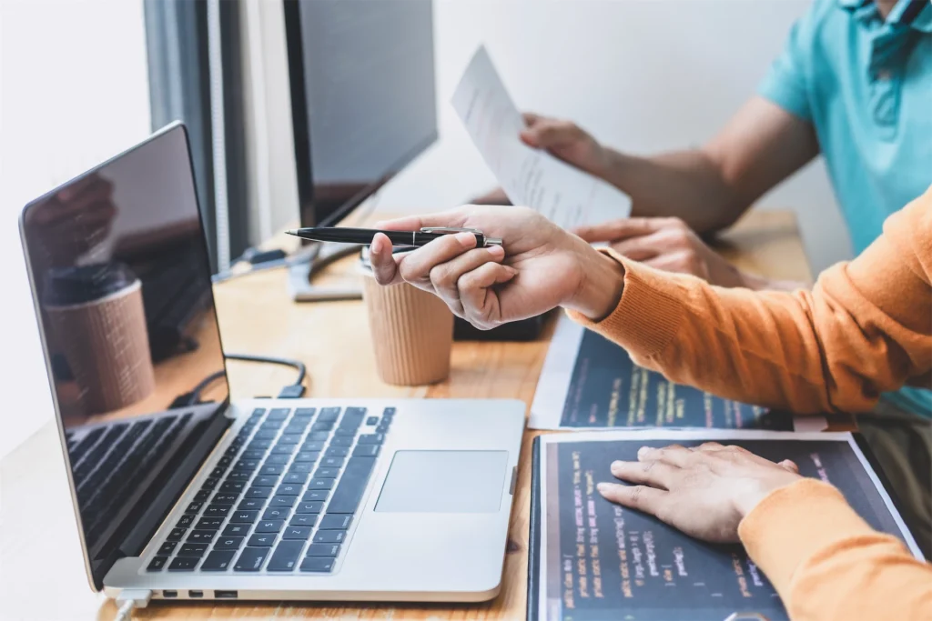 Team reviewing schema code and documents at shared desk